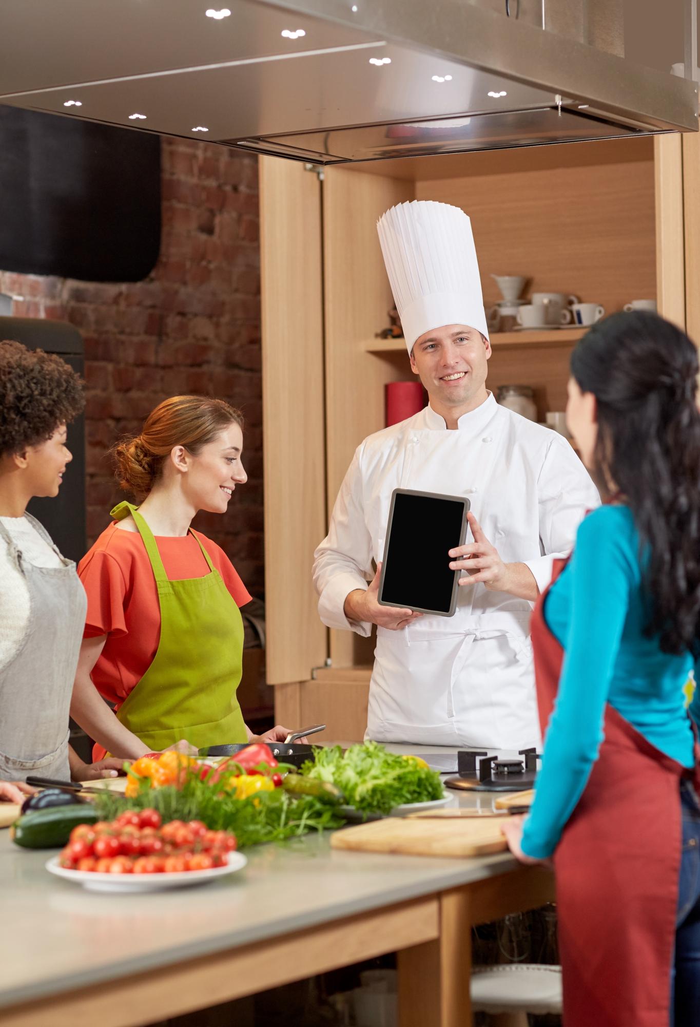 Chef speaking with students in a bright classroom